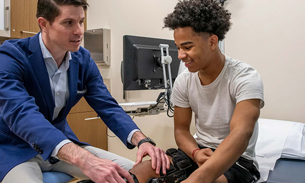 A doctor examines a patient's knee A doctor examines a patient's knee