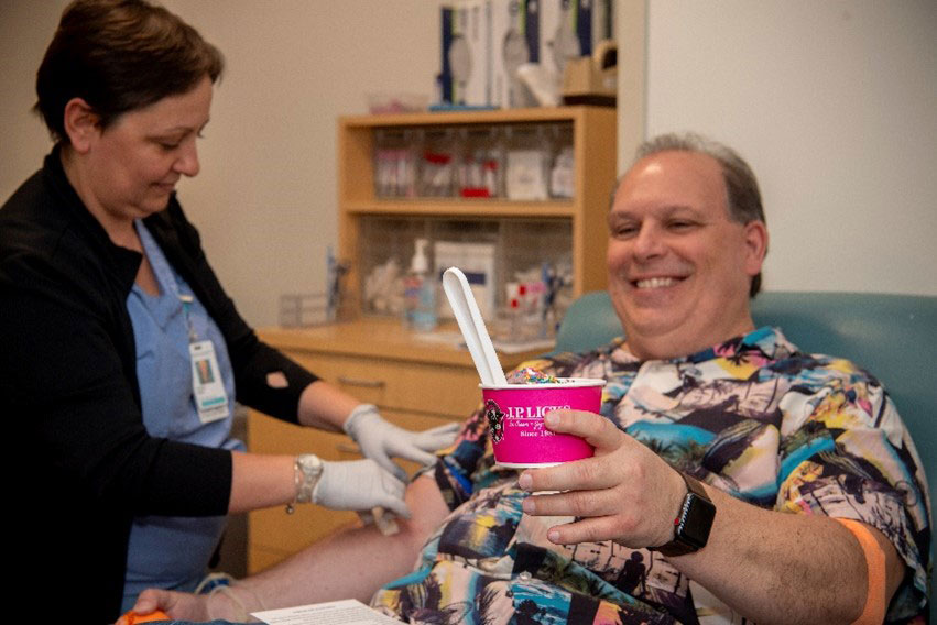 A blood donor holds a bowl of ice cream