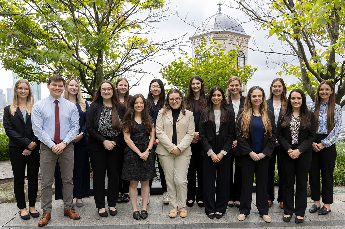 The 2024 Pharmacy residents in a courtyard with trees and a cupola behind them.