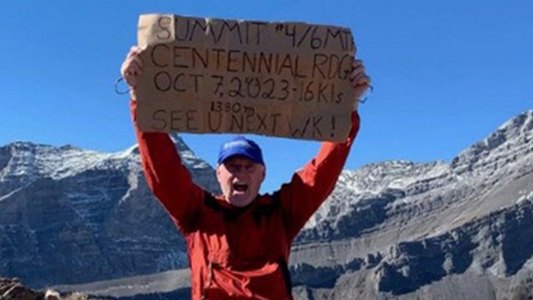 An older man at a mountain summit
