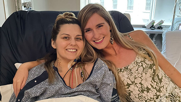 A patient and her friend in a hospital bed