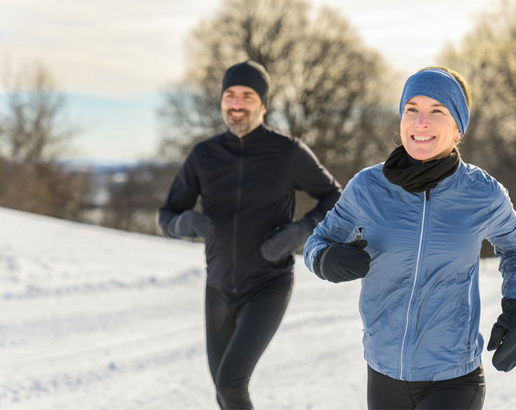 Two joggers outside in snow